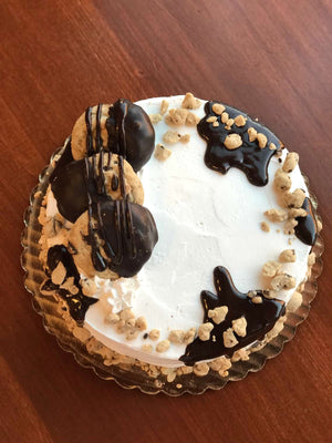 This cake is supreme when it comes to cookie dough. We generously parcel our dough pieces around the top and bottom of our ice cream cake while fudge cascades down the edges. We also include chocolate chip cookies dipped in chocolate to make a delectable display on top of the cake.