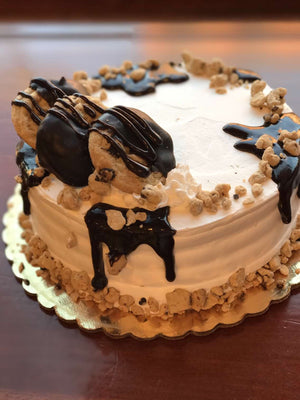 This cake is supreme when it comes to cookie dough. We generously parcel our dough pieces around the top and bottom of our ice cream cake while fudge cascades down the edges. We also include chocolate chip cookies dipped in chocolate to make a delectable display on top of the cake.