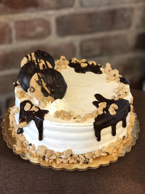 This cake is supreme when it comes to cookie dough. We generously parcel our dough pieces around the top and bottom of our cake while fudge cascades down the edges. We also include chocolate chip cookies dipped in chocolate to make a delectable display on top of the cake.