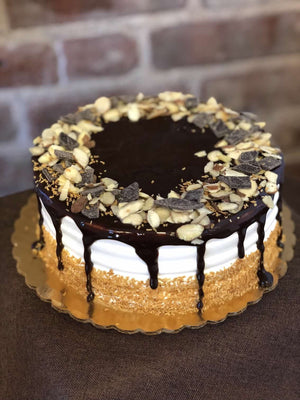 The fruit of the tropics meets ice cream cake. This cake has chocolate fudge fully encompassing the top and drizzling down the edges where you'll find toasted coconut climbing it's way up. The final touch comes from almond slivers and dark chocolate pieces around the top of the cake for an added crunch.