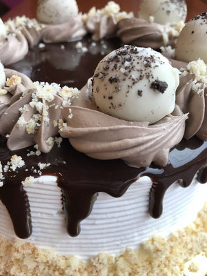 White Chocolate. Chocolate Fudge. Pound Cake. Sounds good doesn't it? Inside of these white chocolate truffles lies a hand rolled ball made of scrumptious pound cake. The truffles are accompanied by dollops of chocolate whipped cream and more pound cake crumbles as a garnish. The middle of the cake is immersed in an overflowing pool of chocolate fudge, perfectly complementing the luscious flavors on this cake.